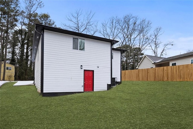 back of house featuring cooling unit and a lawn