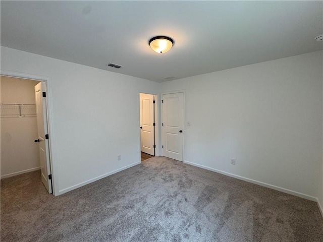 23 Gresham Ct, Dawsonville, GA 30534 - unfurnished bedroom featuring carpet flooring, a walk in closet, and a closet