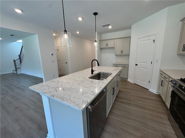 23 Gresham Ct, Dawsonville, GA 30534 - kitchen with appliances with stainless steel finishes, dark wood-style floors, light stone counters, decorative light fixtures, and a center island with sink