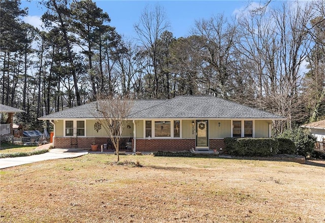 ranch-style house featuring driveway, a shingled roof, a front lawn, and brick siding