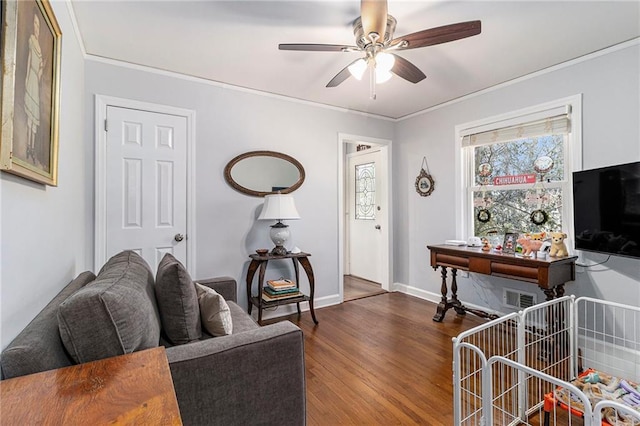 living room with dark wood-style flooring, crown molding, visible vents, ceiling fan, and baseboards