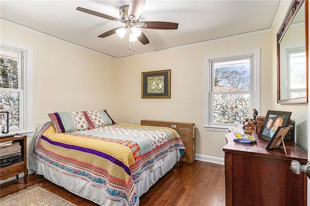 bedroom with ornamental molding, dark wood-type flooring, a ceiling fan, and baseboards