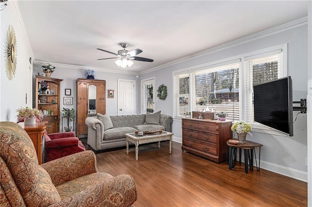 living room featuring ceiling fan, crown molding, baseboards, and wood finished floors