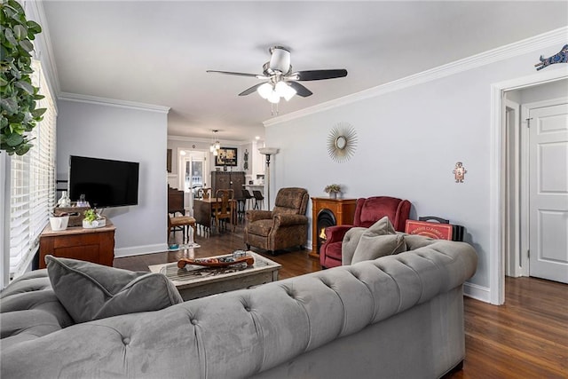 living area with ceiling fan, ornamental molding, dark wood finished floors, and baseboards