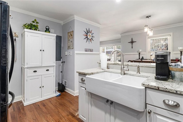 kitchen featuring a sink, white cabinetry, black fridge, dark wood finished floors, and pendant lighting