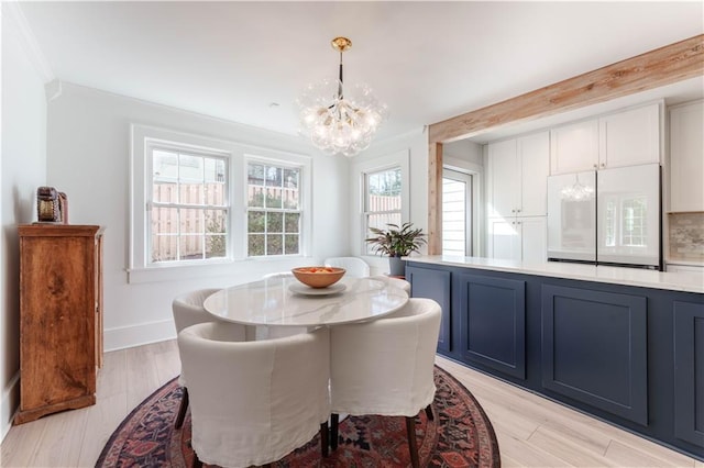 dining room with light wood-style floors, baseboards, and a chandelier