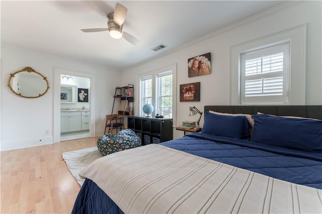 bedroom featuring ensuite bathroom, wood finished floors, visible vents, and crown molding