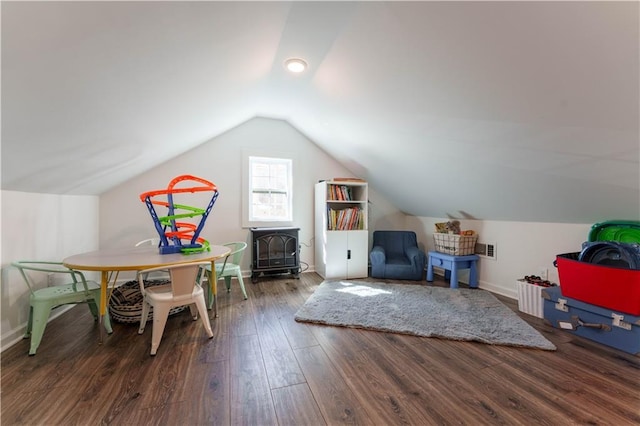 rec room with lofted ceiling, a wood stove, baseboards, and wood finished floors