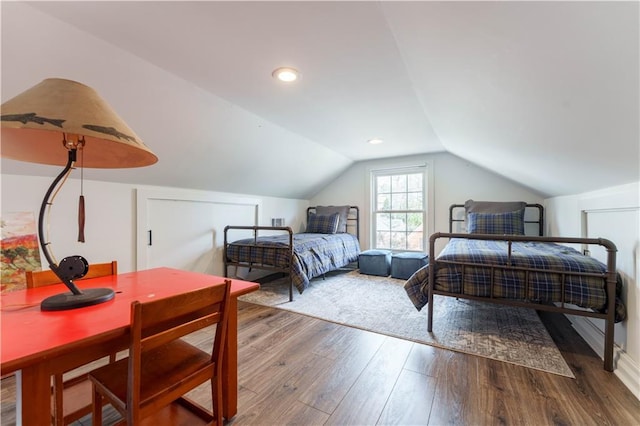 bedroom with lofted ceiling and wood finished floors