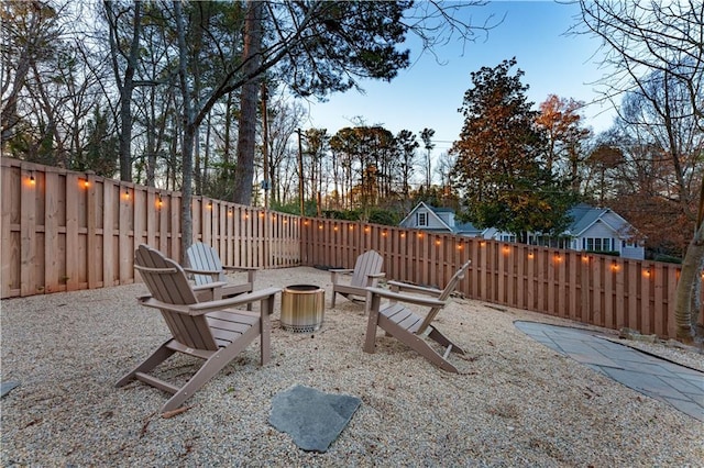 exterior space featuring an outdoor fire pit and a fenced backyard