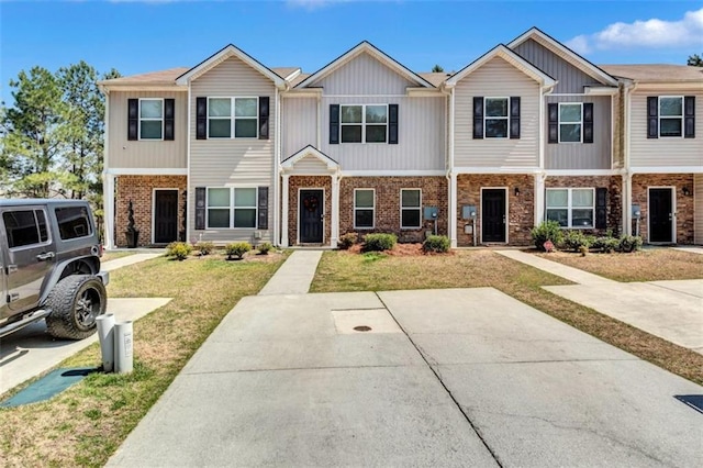 multi unit property featuring board and batten siding and a front yard