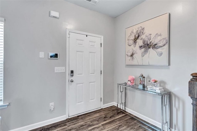 entryway with dark wood-type flooring, baseboards, and visible vents