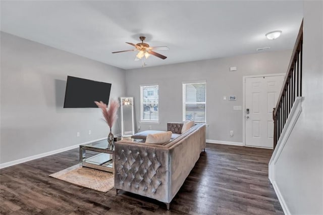 living area with stairway, baseboards, ceiling fan, and dark wood finished floors