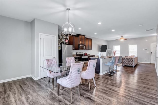 dining area featuring dark wood-style flooring, visible vents, baseboards, recessed lighting, and ceiling fan with notable chandelier