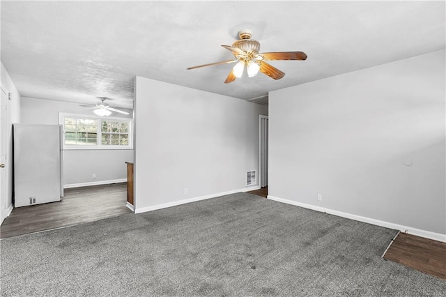 spare room with ceiling fan, vaulted ceiling, and dark colored carpet