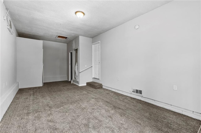 spare room featuring a textured ceiling and carpet flooring