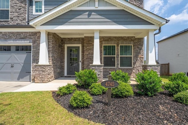 entrance to property featuring covered porch and a garage