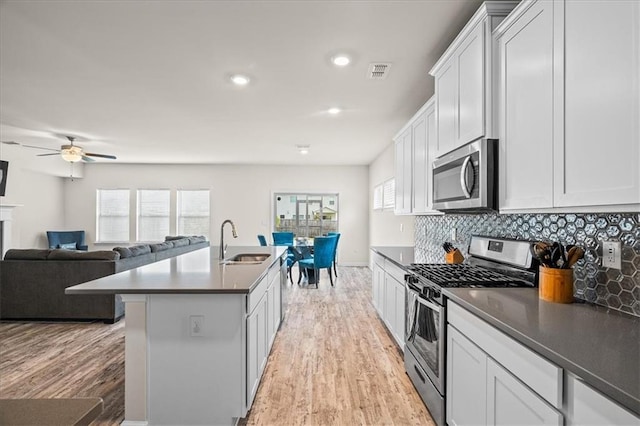 kitchen with a wealth of natural light, white cabinets, appliances with stainless steel finishes, and sink