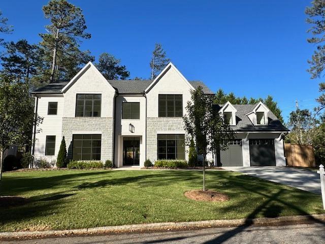 view of front of home with a front lawn, driveway, and a garage