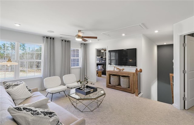 carpeted living area with baseboards, recessed lighting, attic access, and a ceiling fan