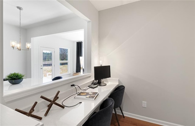 office space featuring dark wood-style floors, baseboards, and an inviting chandelier