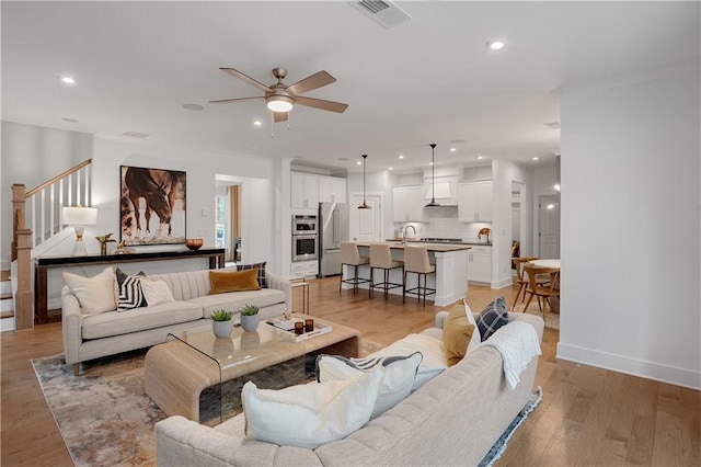 living room with visible vents, ceiling fan, recessed lighting, and stairs