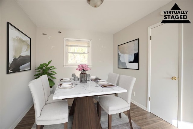 dining space featuring baseboards and wood finished floors