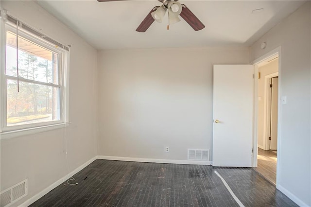 empty room with visible vents, ceiling fan, baseboards, and wood finished floors