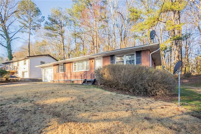 ranch-style home with a front yard, brick siding, and an attached garage