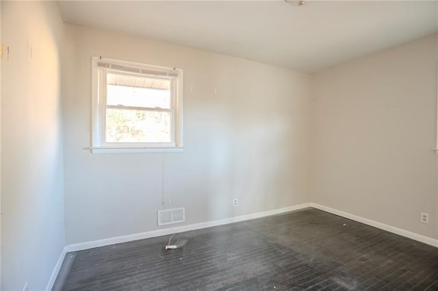 empty room featuring baseboards and visible vents