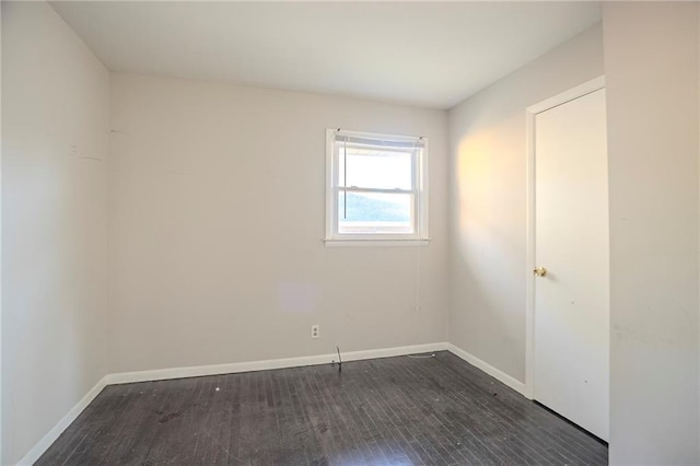 unfurnished room with baseboards and wood finished floors