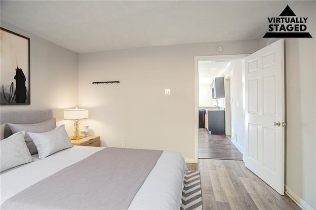 bedroom featuring wood finished floors and baseboards