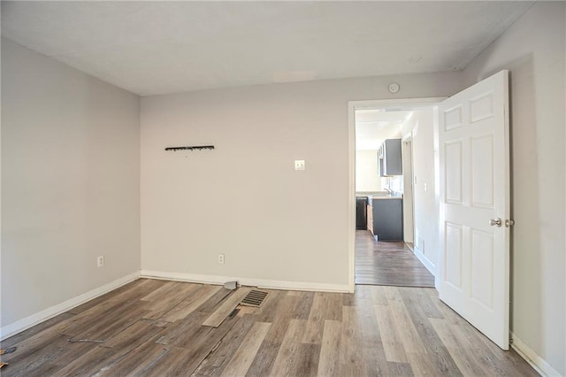 empty room with baseboards and wood finished floors