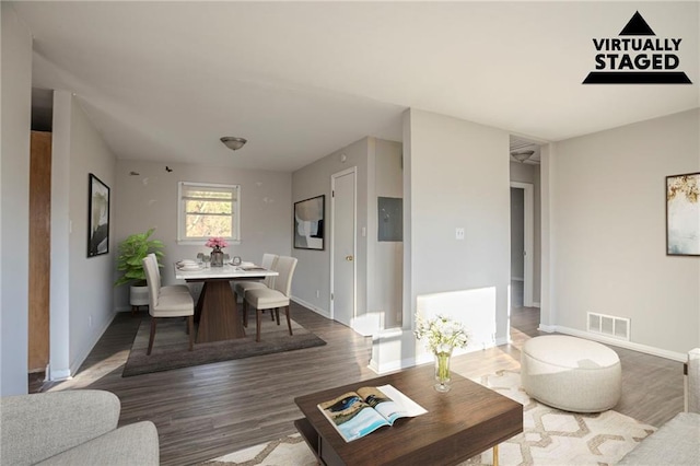 living room with visible vents, baseboards, and wood finished floors