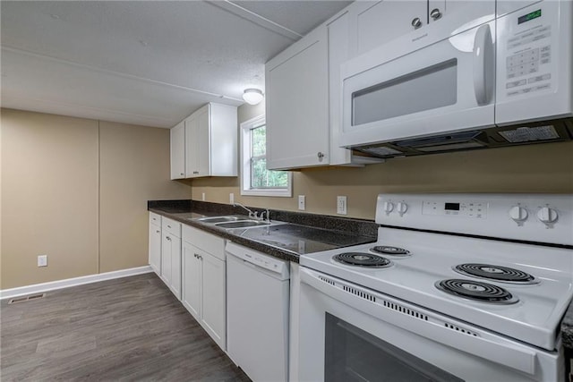 kitchen featuring dark hardwood / wood-style flooring, white cabinetry, sink, and white appliances