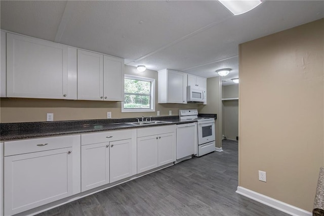 kitchen with white cabinets, dark hardwood / wood-style flooring, white appliances, and sink