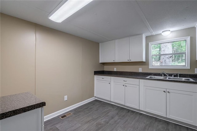 kitchen featuring sink, white cabinets, and dark wood-type flooring