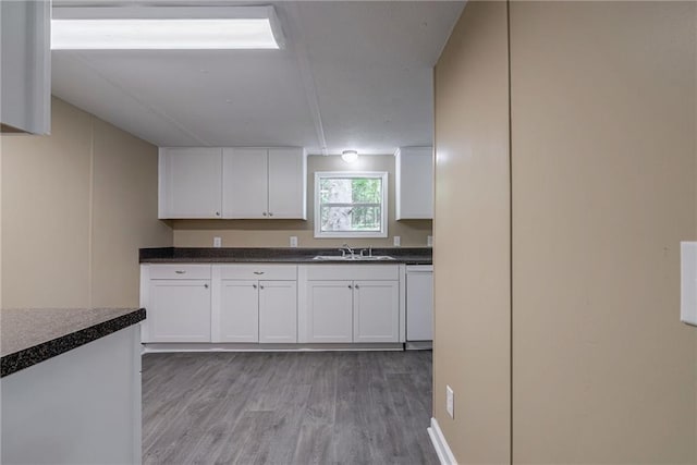 kitchen featuring white cabinetry, sink, dishwasher, and light wood-type flooring