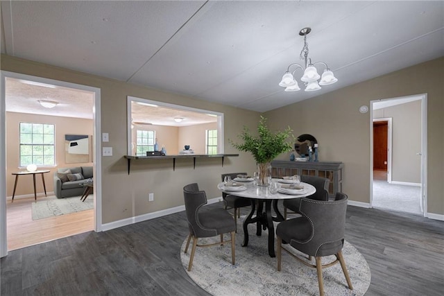 dining space featuring dark wood-type flooring and a chandelier