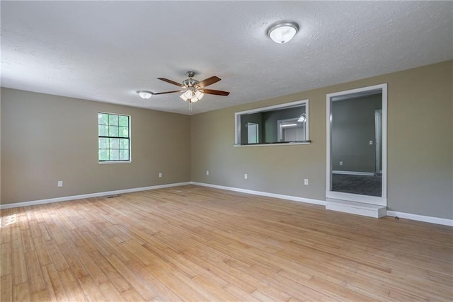 unfurnished room with a textured ceiling, light hardwood / wood-style flooring, and ceiling fan