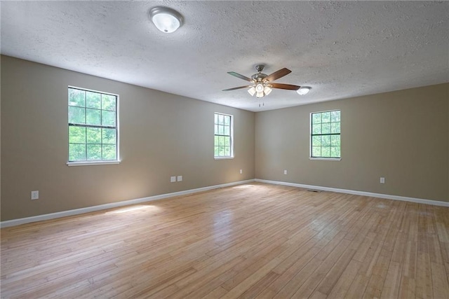 spare room with ceiling fan, light hardwood / wood-style flooring, and a textured ceiling