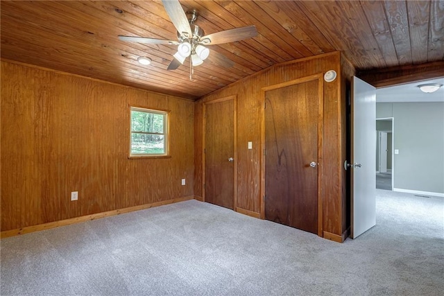 unfurnished bedroom with wooden walls, carpet floors, ceiling fan, and wooden ceiling