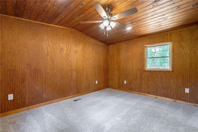 unfurnished room featuring lofted ceiling, wood walls, wooden ceiling, and carpet floors