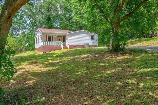 view of front of house with cooling unit, a porch, and a front yard