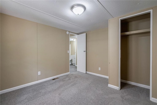 unfurnished bedroom with a textured ceiling, carpet floors, and a closet