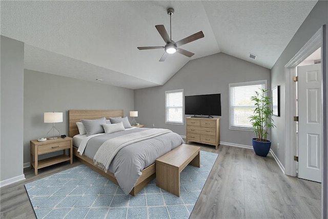 bedroom featuring visible vents, baseboards, wood finished floors, and lofted ceiling