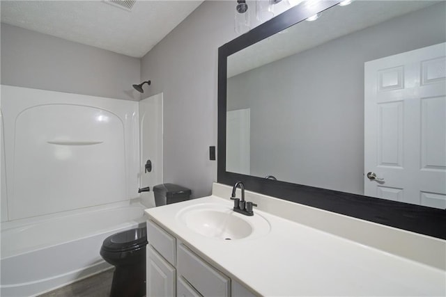 full bath with bathtub / shower combination, wood finished floors, vanity, and toilet