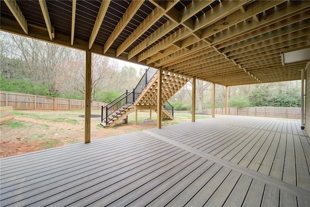 wooden terrace with a fenced backyard and stairs