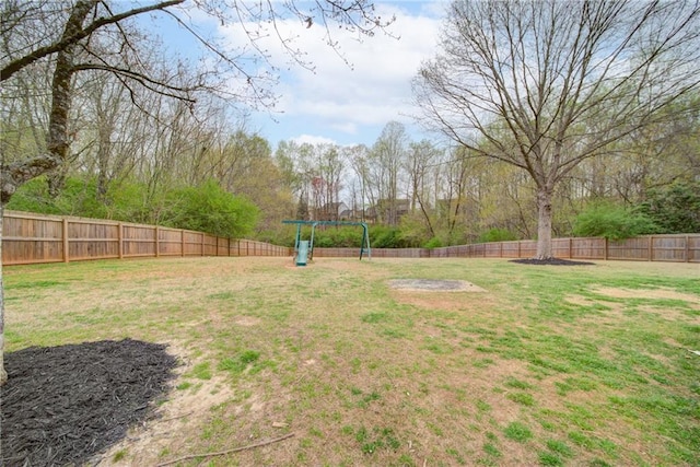 view of yard with a fenced backyard and a playground
