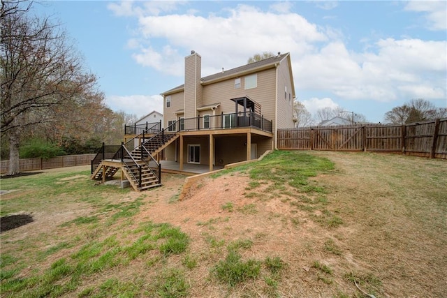 rear view of property featuring stairs, a fenced backyard, and a lawn